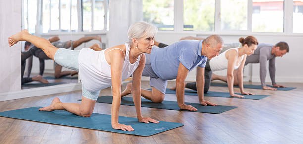 Seniors group Hatha yoga class, gentle practice in a studio