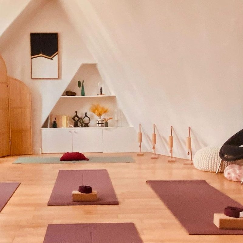 The SWA yoga studio in Paris 17, overlooking the sky and the rooftops of Paris: wooden floor, mats, blocks and straps ready for a small-group class