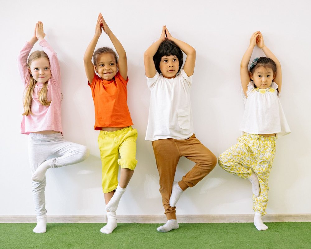 Enfants en posture de l’arbre lors d’un cours de yoga ludique